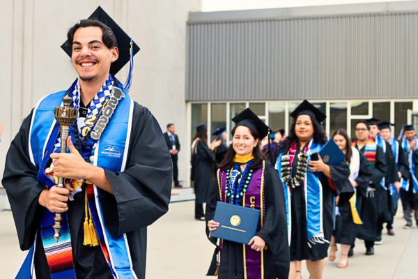 Student Marshal leading CSUSM graduates out of the Sports Center