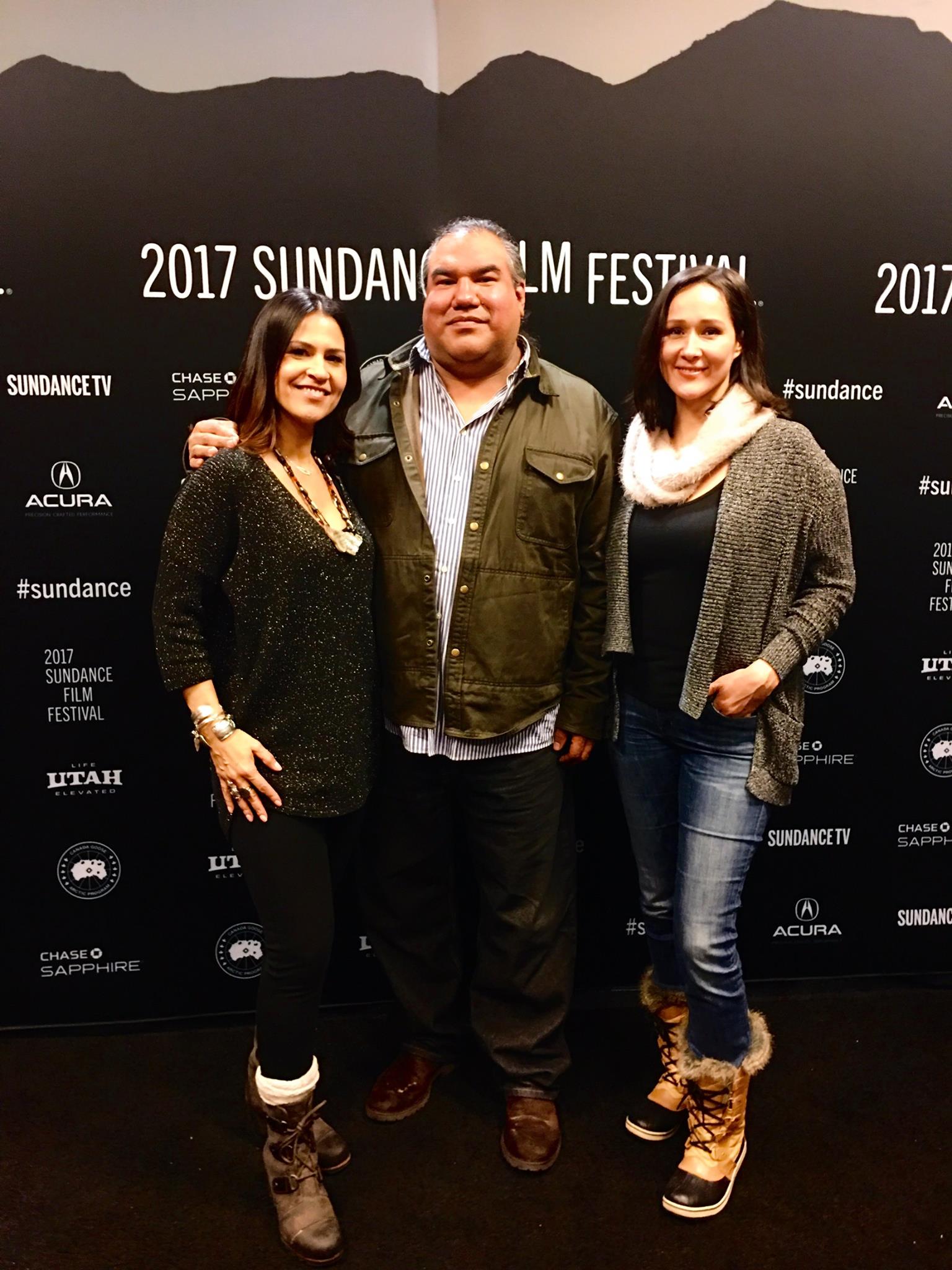 Dr. Joely Proudfit, Chris Eyre, and another woman at the Sundance Film Festival, standing in front of a black photo background wall with logos and the words "2017 Sundance Film Festival" in white