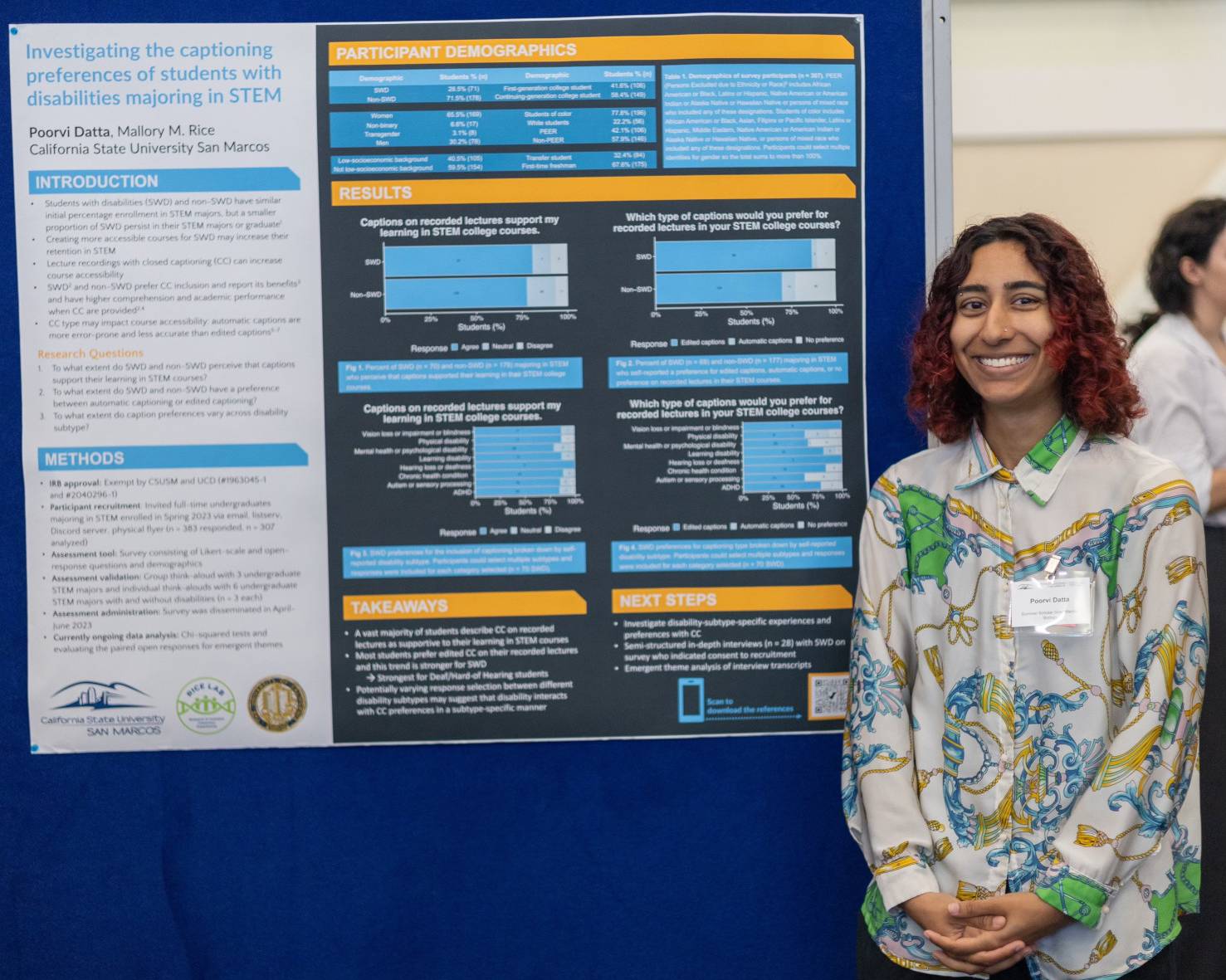 Student smiling in front of poster presentation